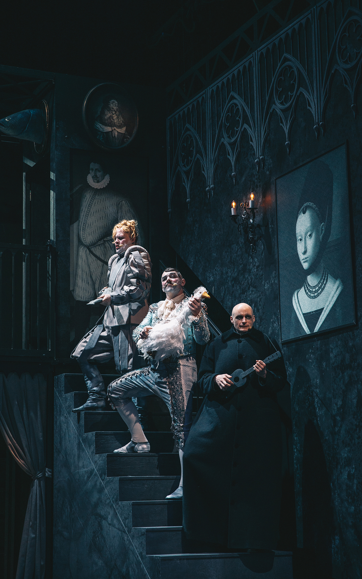 Na stopnicah stojijo Prednik Addams (Gašper Jarni), Prednik Addams (Gaber K. Trseglav) in Gnoj Addams (Jaka Lah). Prvi drži v rokah ribo, drugi gos in tretji ukulelo. Avtor fotografije: Peter Giodani.