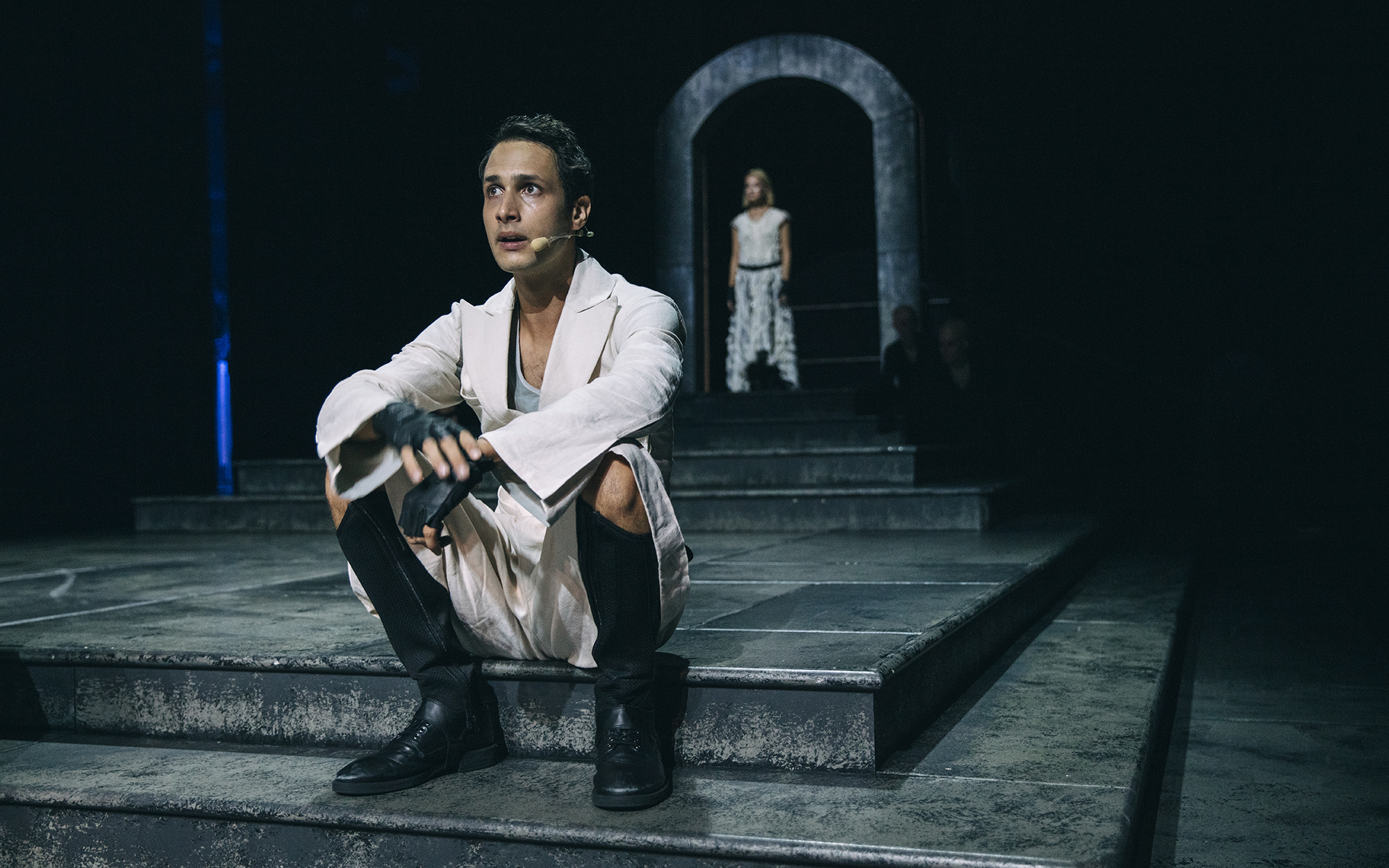Mladi Kalaf (Voranc Boh) sedi na stopnicah. Opazuje ga Turandot (Viktorija Bencik Emeršič). Avtor fotografije: Peter Giodani.