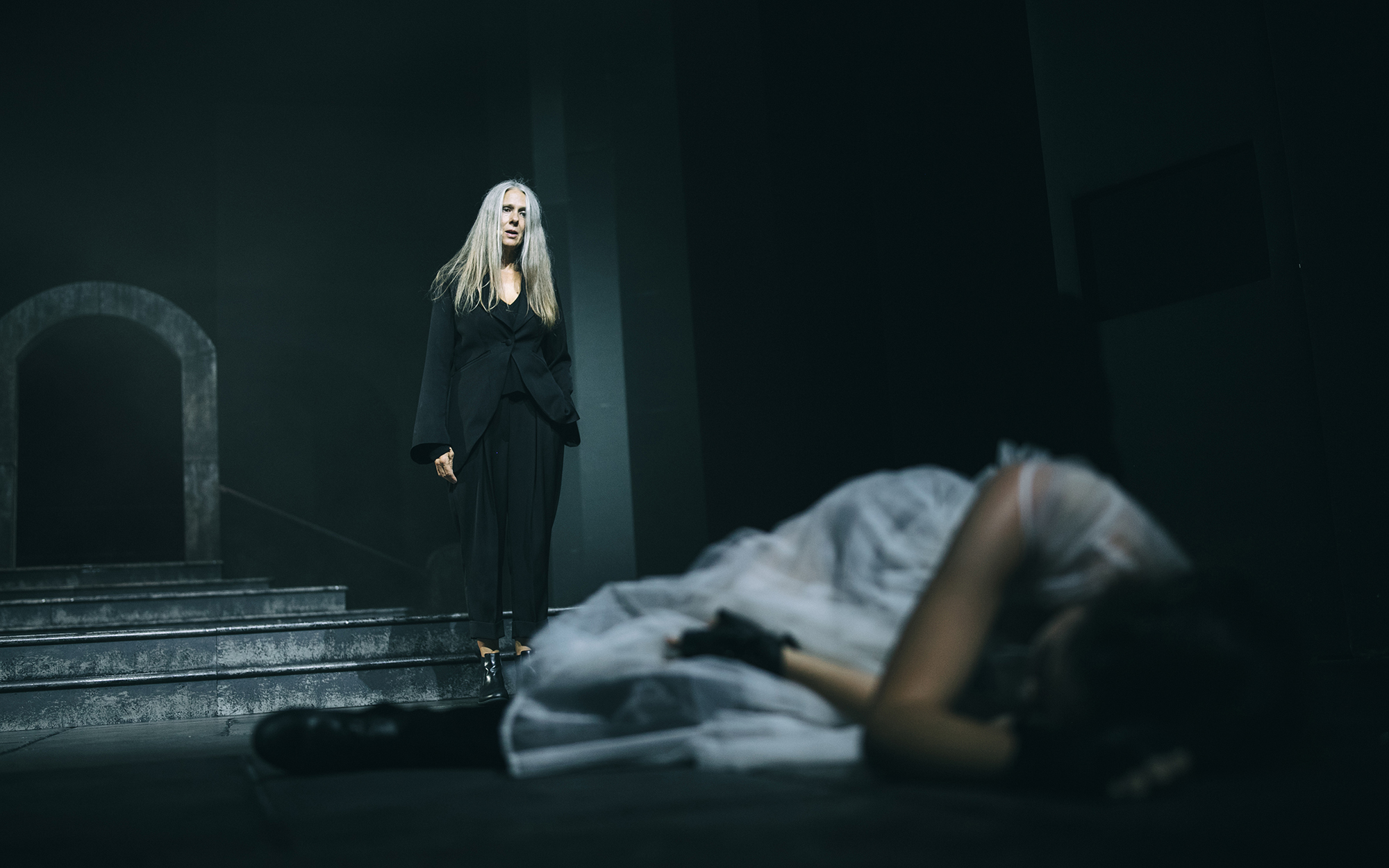 Drugi angel (Nataša Tič Ralijan) se približuje Mladi Turandot (Lara Wolf), ki leži na tleh. Avtor fotografije: Peter Giodani.