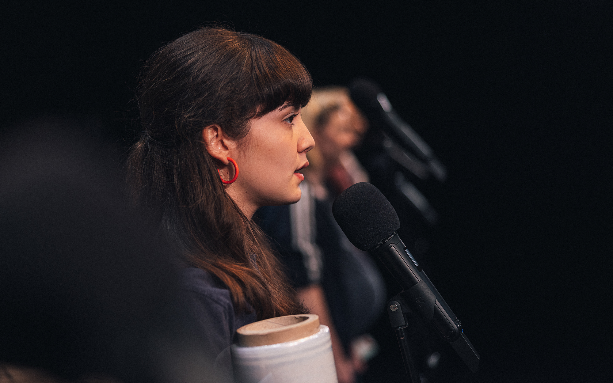 Na odru pred mikrofonom stoji Lana (Lara Wolf) in nekaj pripoveduje. V rokah drži velik zvitek plastične folije za ovijanje različnih predmetov.